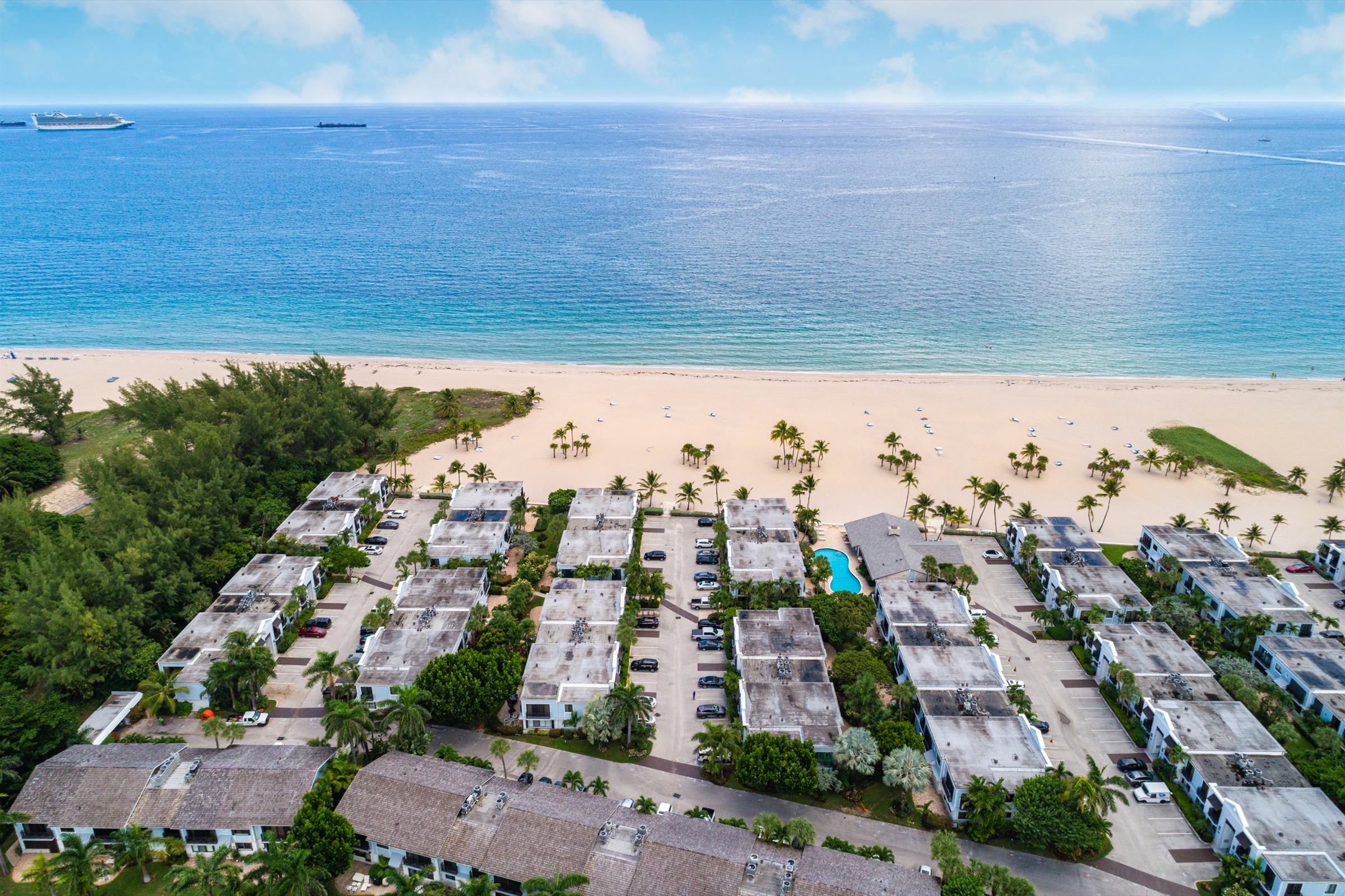 Aerial view of two-storey oceanfront residences on Fort Lauderdale beach, with the Atlantic beyond.